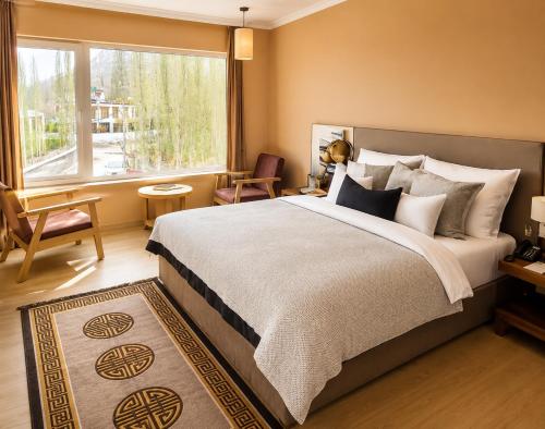 a bedroom with a large bed and a large window at Hotel Dekiling by Eastlynn Collections in Leh