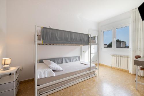 a bedroom with two bunk beds and a desk at MM Delta Holidays in El Lligallo del Gànguil