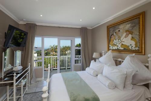 a bedroom with a large bed and a balcony at Seaview Manor Exquisite Bed & Breakfast in Durban