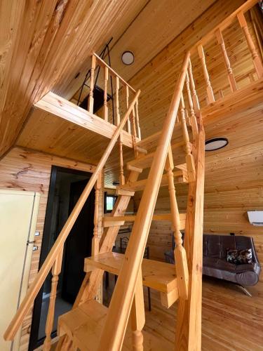 a wooden spiral staircase in a log cabin at Cottages in Kobuleti