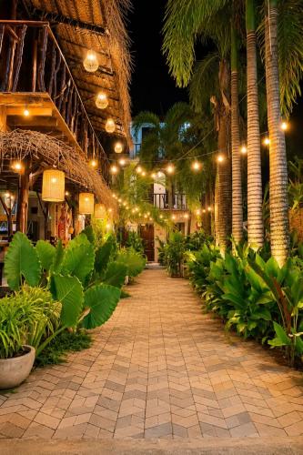 a walkway in a resort with palm trees and lights at Coco Palm Villa and Cabanas in Tangalle
