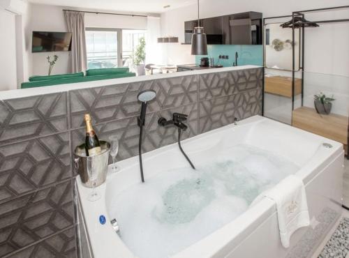 a bath tub with a bottle of wine in it at Ermou w Jacuzzi Acropolis View Monastiraki in Athens