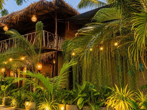 a building with a bunch of plants and lights at Coco Palm Villa and Cabanas in Tangalle