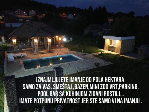 a advertisement for a house with a swimming pool at night at Čajića avlija pool house in Obrenovac