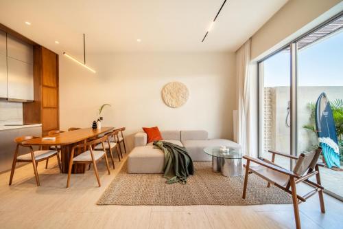 a living room with a table and a couch at Surfside Uluwatu Resort in Uluwatu