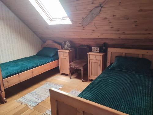 a attic bedroom with two beds and a window at Glas house Aljmaš in Aljmaš