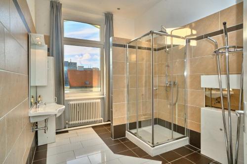 a bathroom with a shower and a sink and a window at 2 bedrooms & free parking in Vienna