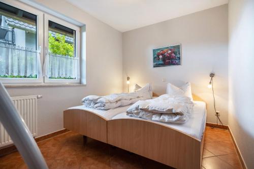 a bedroom with a bed with white sheets and a window at Haus S 42 in Röbel