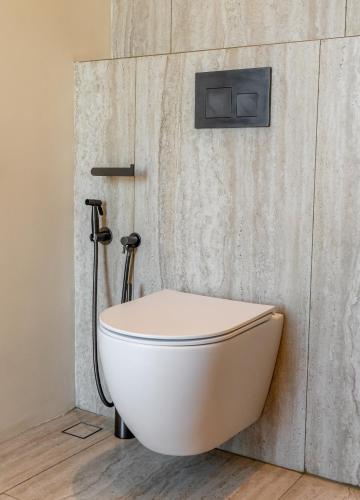 a white toilet in a bathroom with a shower at Surfside Uluwatu Resort in Uluwatu