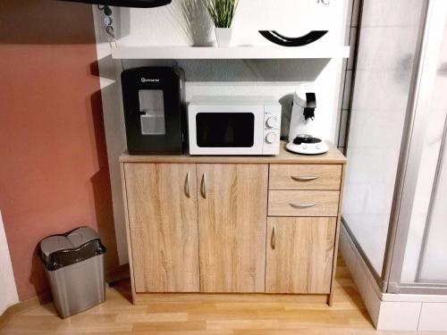 a microwave sitting on top of a wooden cabinet at Pension am Kirchberg - Zimmer 1 in Daun