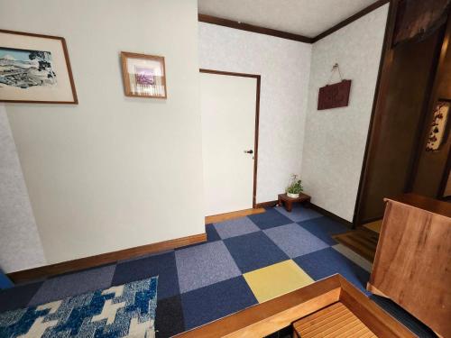 a room with a hallway with a door and a floor at Guesthouse Face to Face in Fujinomiya