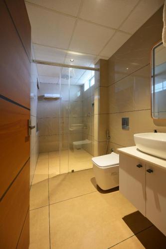 a bathroom with a shower and a toilet and a sink at Leal Resort-Wayanad in Meppādi