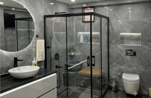 a bathroom with a glass shower and a sink at premium category 2 bedrooms apartment in Lahore