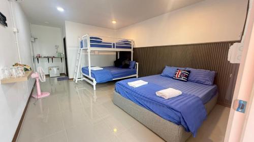 a bedroom with two bunk beds and a ladder at ปลายเขื่อนแคมปิ้ง บ้านวิวเขื่อน in Sirindhorn