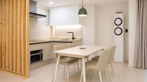 a kitchen with a white table and chairs in a room at Pocheon Skygaram Pension in Pocheon