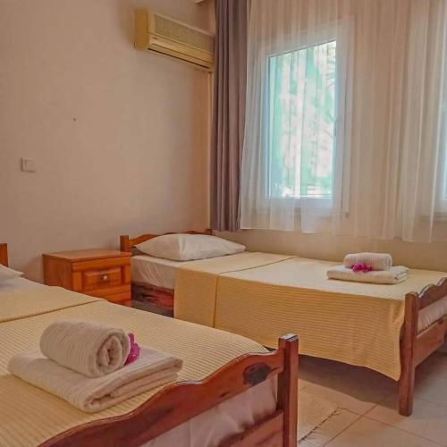 a bedroom with two beds and a window at Garden-view suite room in Ortaca