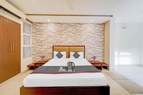 a bedroom with a large bed and a brick wall at RG Suites - Royapettah in Chennai