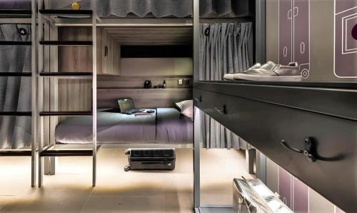 a bedroom with a bunk bed with a suitcase in it at Coller Boutique Hostel in Singapore