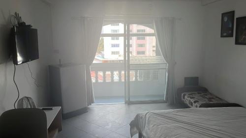a bedroom with a bed and a large window at Niruan apartment in Pattaya