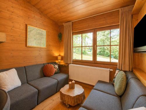 a living room with a couch and a table at Chalet in Wörgl near Ski Lift in Hopfgarten im Brixental