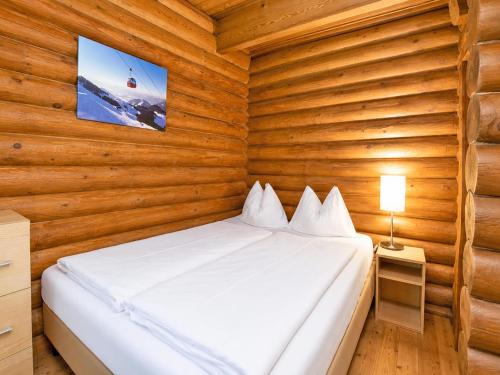 a bedroom with a bed in a wooden wall at Rustic chalet near SkiWelt Wilder Kaiser in Salvenberg