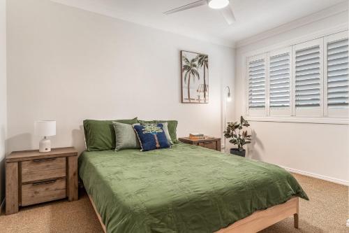 a bedroom with a green bed and a window at 1-41 Park Street in Evans Head