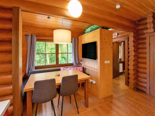 a dining room with a wooden table and a television at Rustic chalet near SkiWelt Wilder Kaiser in Salvenberg
