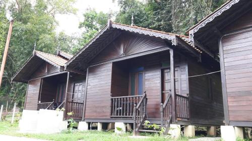 a wooden cabin with a porch and a balcony at Happy Paradise in Kampung Janda Baik