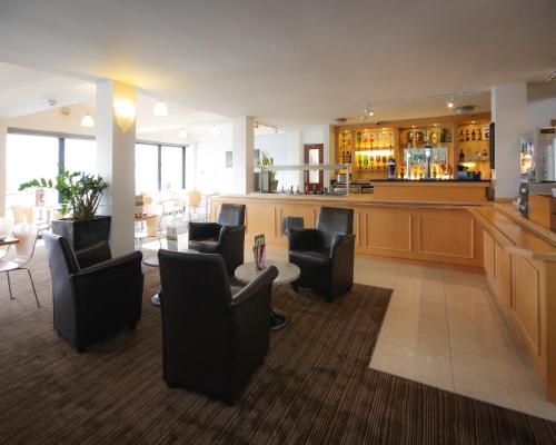 uma sala de espera com cadeiras pretas e um bar em The Dolby Hotel Liverpool - Free city centre parking em Liverpool