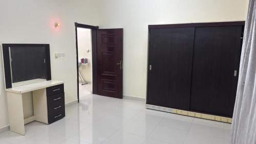 a bathroom with black cabinets and a tv and a mirror at هدى صلالة in Salalah