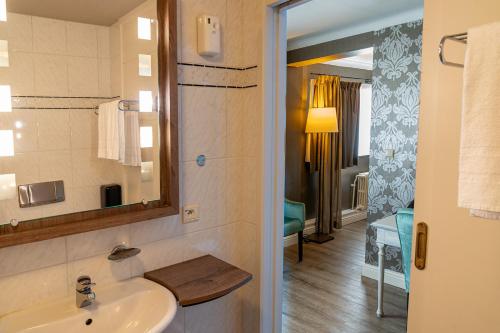 a bathroom with a sink and a mirror at Hotel Mardaga in As