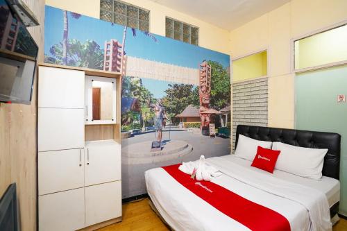 a bedroom with a bed with a painting on the wall at RedDoorz at Gangnam Hotel near Mall Olympic Garden in Betek