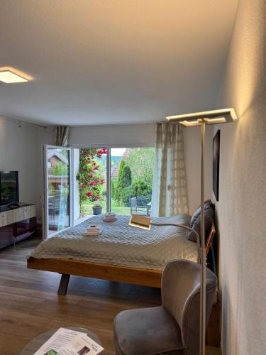 a bedroom with a bed and a large window at Ferienglück Unterkirnach in Unterkirnach