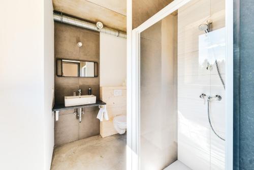 a bathroom with a shower and a toilet and a sink at Daft Hotel & Glamping in Malmedy