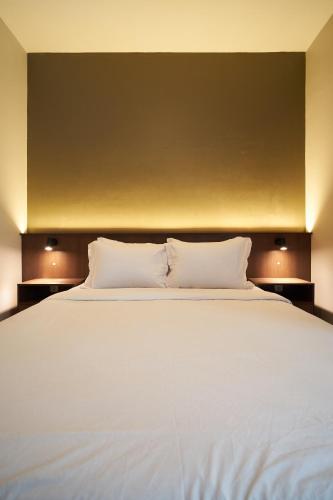 a large white bed with two pillows on it at Kanna Stay in Semolowaru