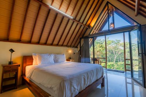 a bedroom with a bed and a large window at The Grembeng in Undisan