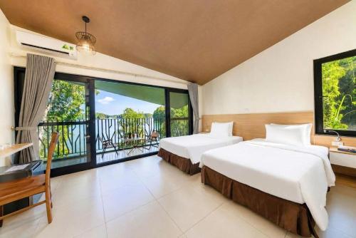 two beds in a room with a balcony at An Binh Village in Yên Bình