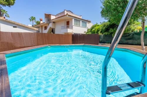 a swimming pool with a hose in front of a house at Llinya 7 in El Arenal