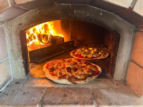 two pizzas are in a brick oven at Pulsà dol Sìndec in Vilminore
