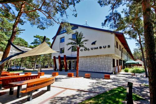 a building with benches in front of it at Columbus Rowy in Rowy