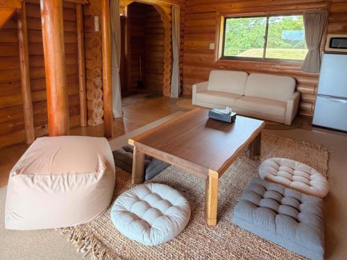 a living room with a table and a couch at Maruta ひたち大宮 in Takabu