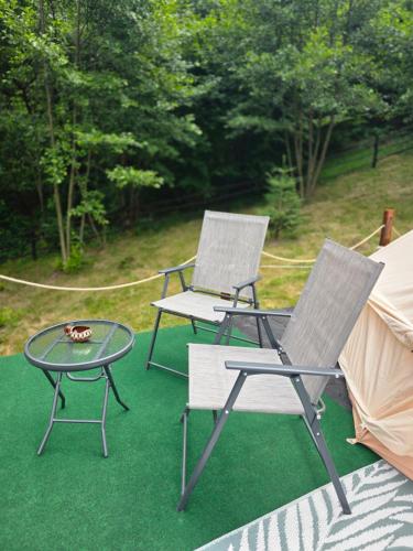 two chairs and a table and a tent at Camping Inima Retezatului in Nucşoara