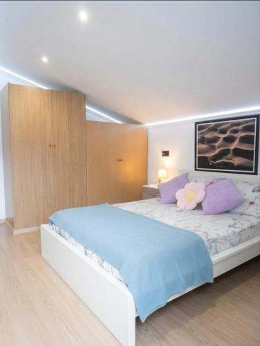 a bedroom with a large bed with purple pillows at Casa Evita in Sanxenxo