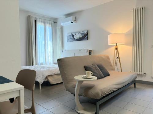 a bedroom with a bed and a couch and a table at Suite Terrazza Mazzini in Molinella