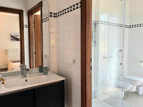 a bathroom with a sink and a toilet and a shower at Suite Terrazza Mazzini in Molinella