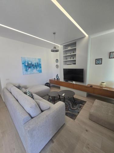 a living room with a couch and a flat screen tv at Palase GC 141 in Palasë