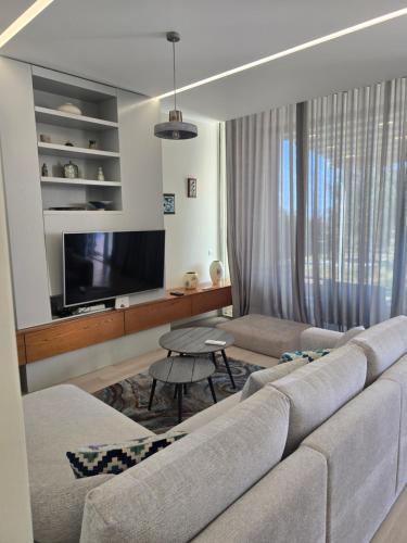 a living room with a couch and a tv at Palase GC 141 in Palasë
