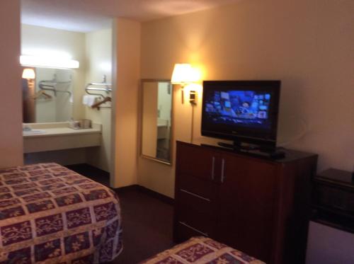 Habitación de hotel con TV y cama en Days Inn by Wyndham York Alabama, en York