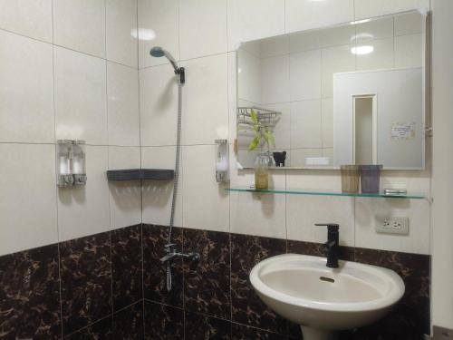 a bathroom with a sink and a mirror at Kinmen Huan Bei 88 B&B in Jincheng