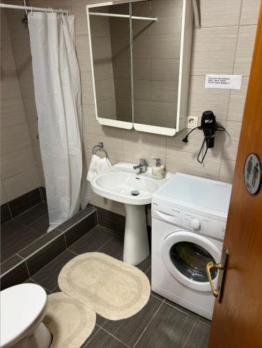a bathroom with a washing machine and a sink at Denis House in Keramoti